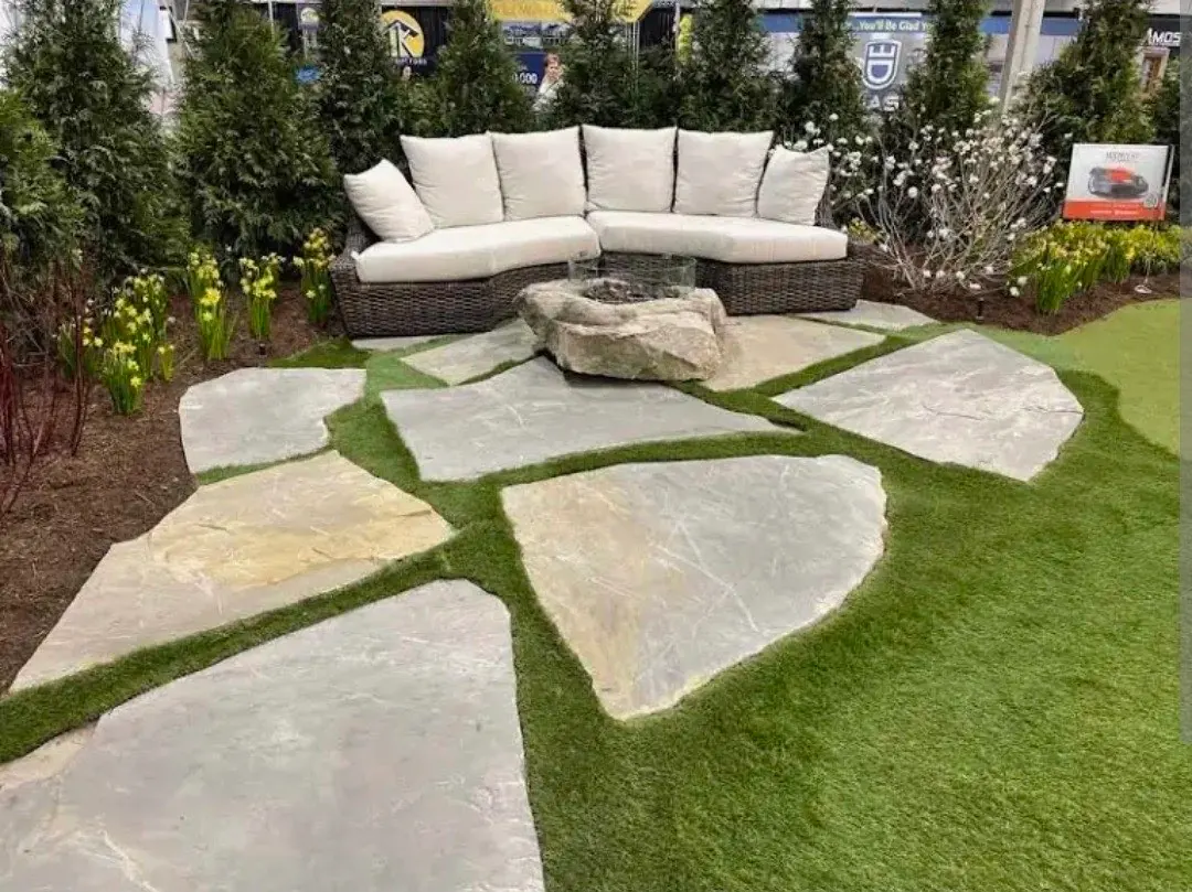 Flagstone patio with grass joints and outdoor lounge seating - Natural Stone Freeport FL